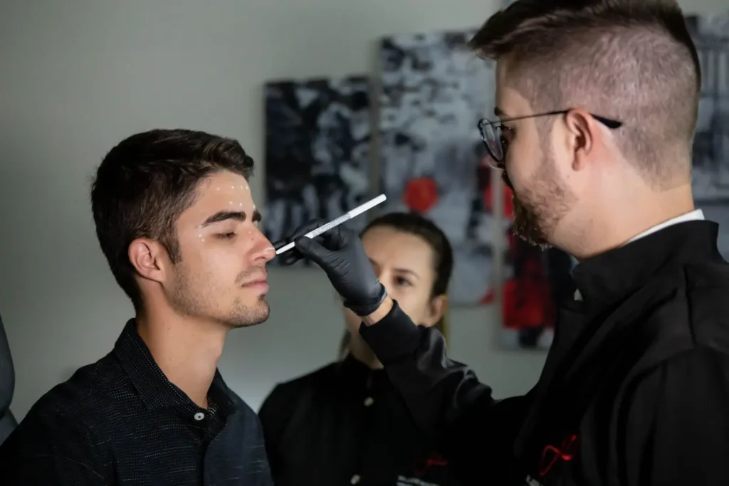 A man marking his client’s face