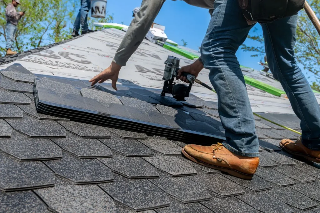 Professional roofer installing shingles on new roof