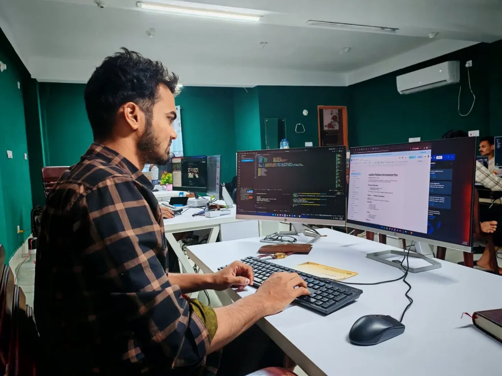 Focused developer at dual monitor setup
